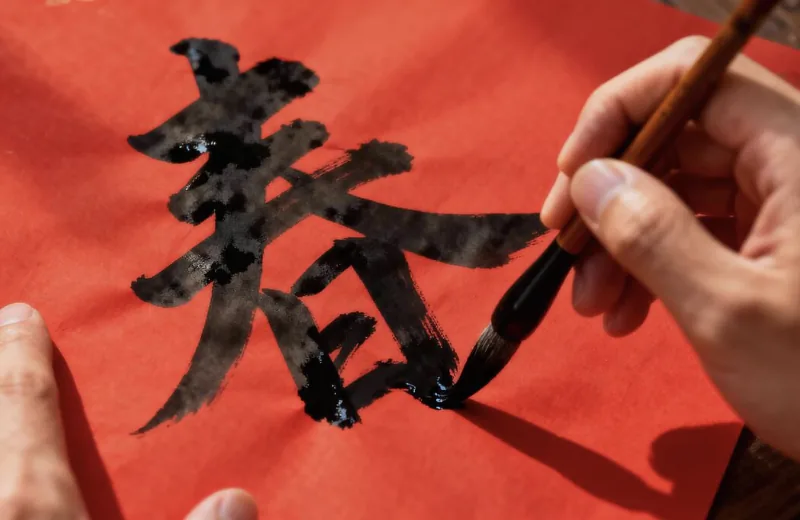 Hand writing spring character on red paper